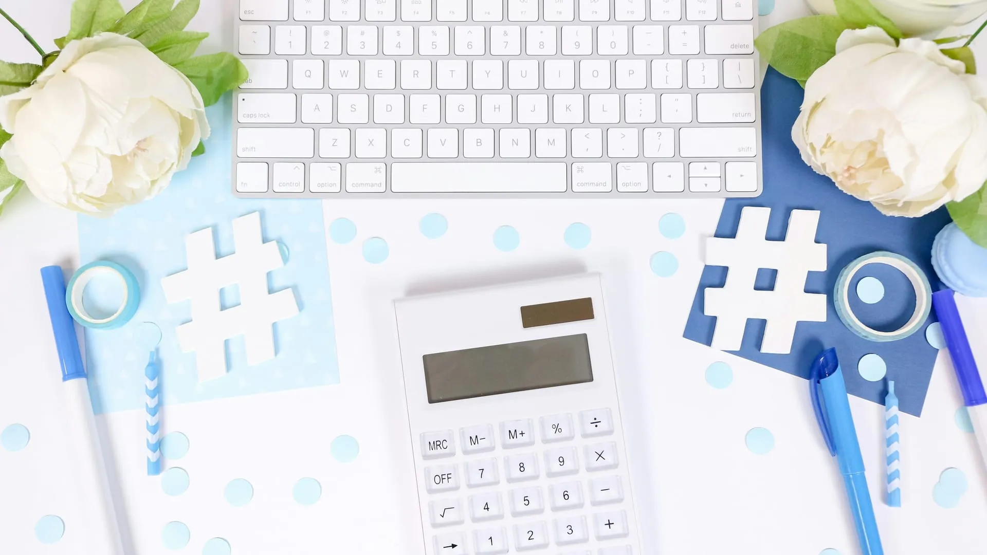 A calculator and pen resting on a clean desk surface